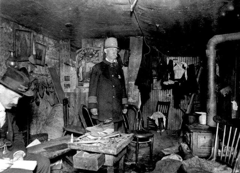 Два сотрудника Жилищного департамента обследуют жилой подвал, 1900 год