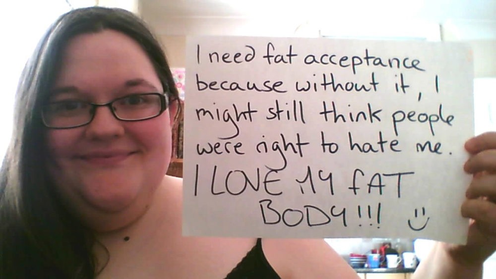Типичный представитель «движения за принятие ожирения». Надпись на бумаге: «Я должна принять своё ожирение, потому что без этого я бы по прежнему считала, что у людей есть право ненавидеть меня. Я ЛЮБЛЮ СВОЁ ЖИРНОЕ ТЕЛО!!! :)»